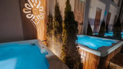 Zewnętrzne jacuzzi z drewnianymi panelami i roślinnością