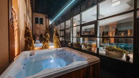 Jacuzzi zewnętrzne z widokiem przez szkło na halę basenową